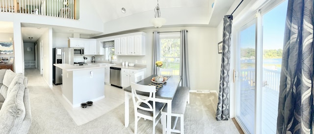 kitchen with white cabinetry, a center island, sink, decorative light fixtures, and appliances with stainless steel finishes