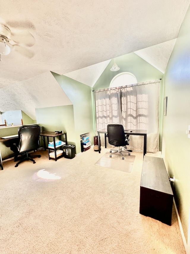 carpeted home office featuring vaulted ceiling and ceiling fan