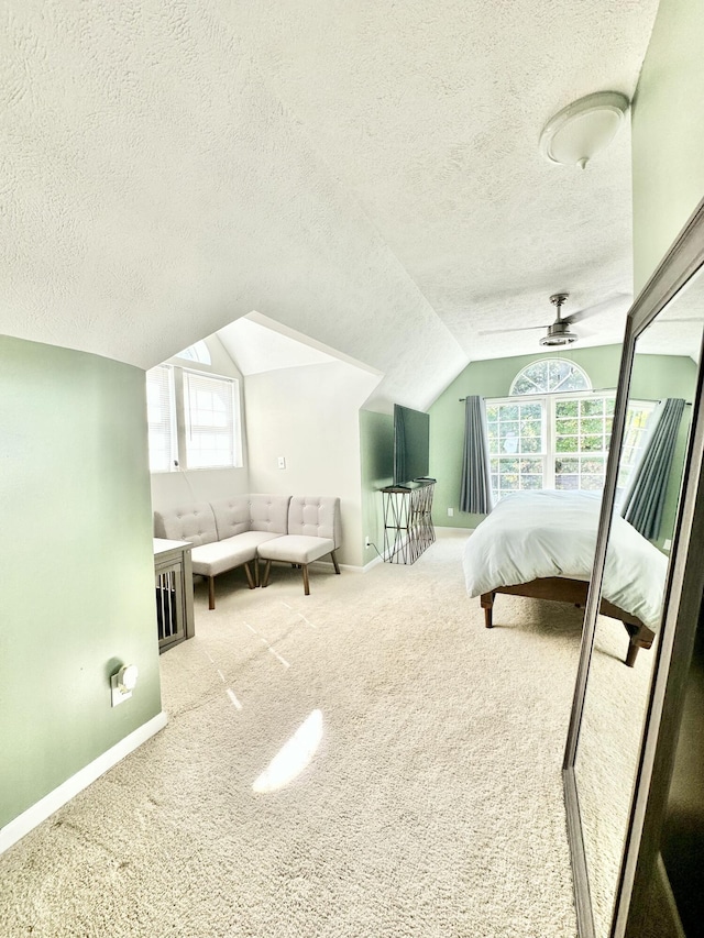 carpeted bedroom with a textured ceiling, ceiling fan, and lofted ceiling