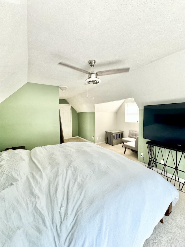 carpeted bedroom featuring a textured ceiling, ceiling fan, and lofted ceiling