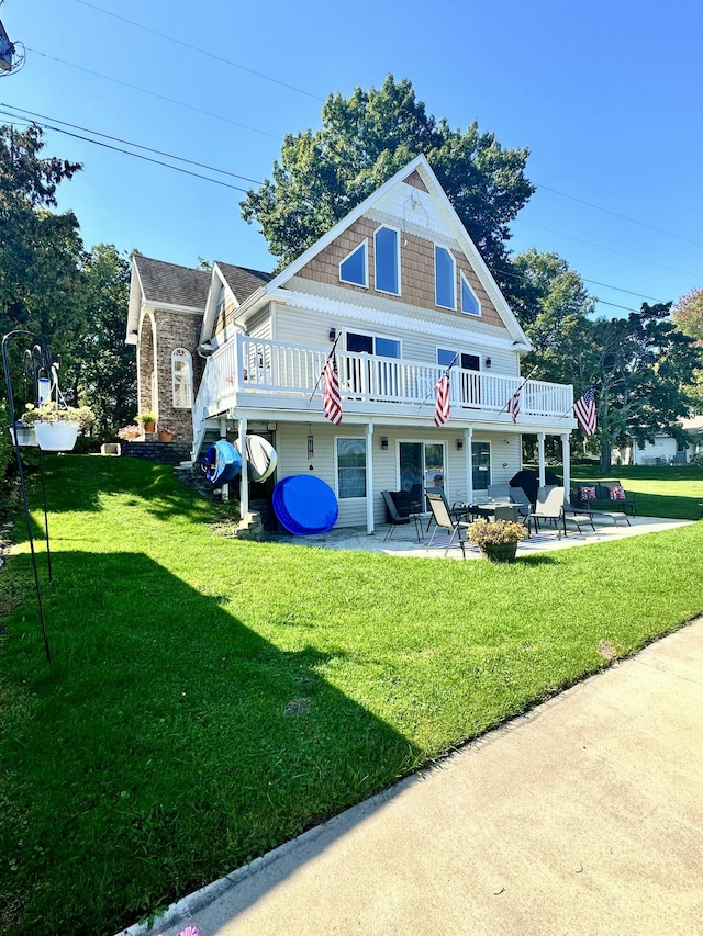 rear view of house featuring a patio area, a yard, and a balcony