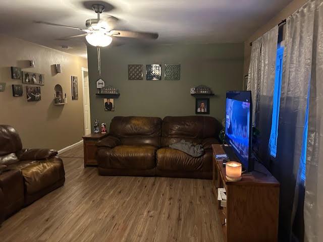 living room featuring ceiling fan and wood-type flooring