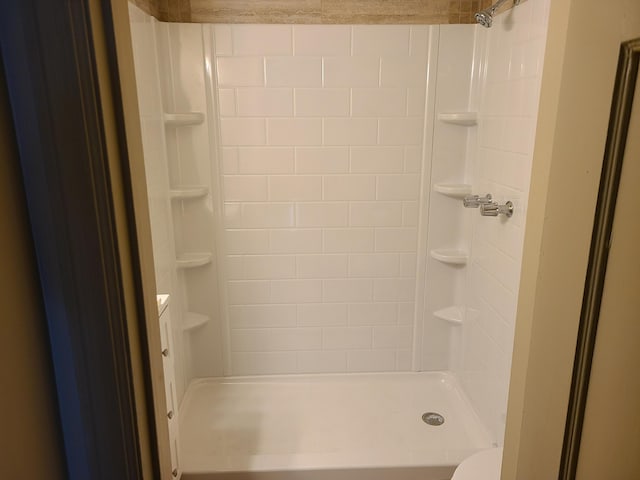 bathroom with a stall shower and toilet