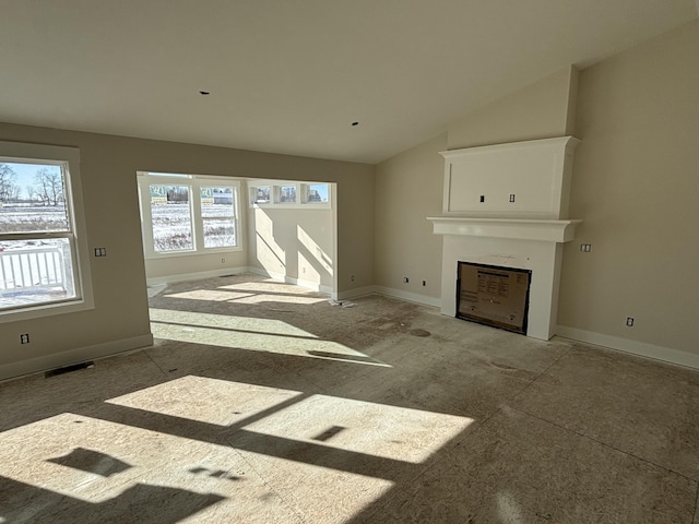 unfurnished living room featuring vaulted ceiling