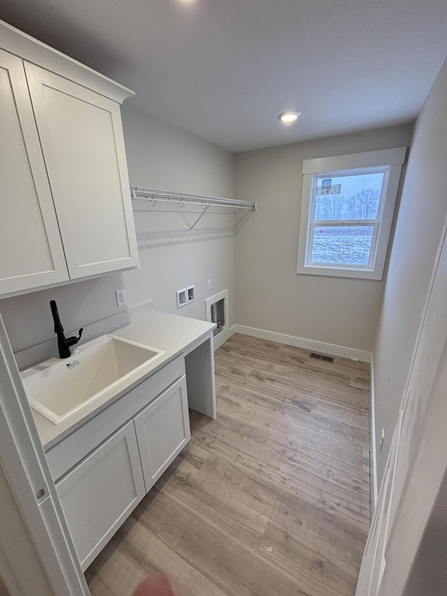 laundry room featuring washer hookup, light wood-style flooring, visible vents, and a sink