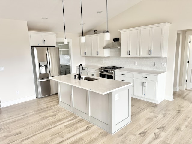 kitchen with wall chimney range hood, stainless steel appliances, a sink, and light countertops