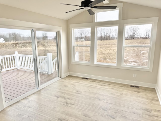 unfurnished sunroom featuring visible vents, vaulted ceiling, and a ceiling fan