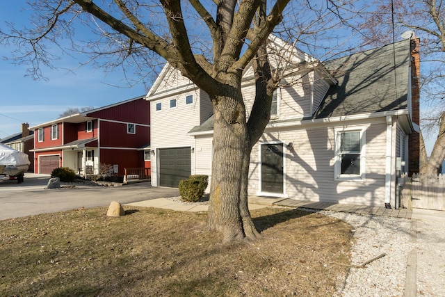 view of side of property with driveway and an attached garage