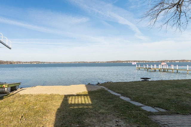 view of dock with a water view and a yard