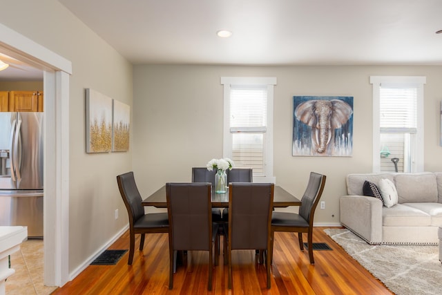 dining room featuring baseboards, visible vents, and light wood finished floors