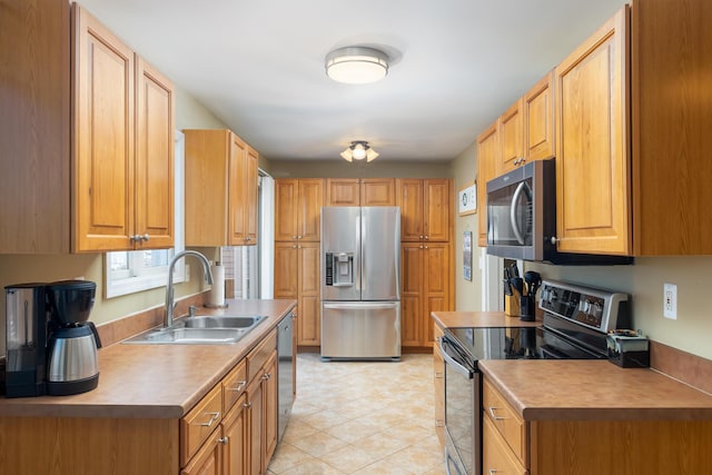 kitchen with a sink, stainless steel appliances, and light tile patterned flooring