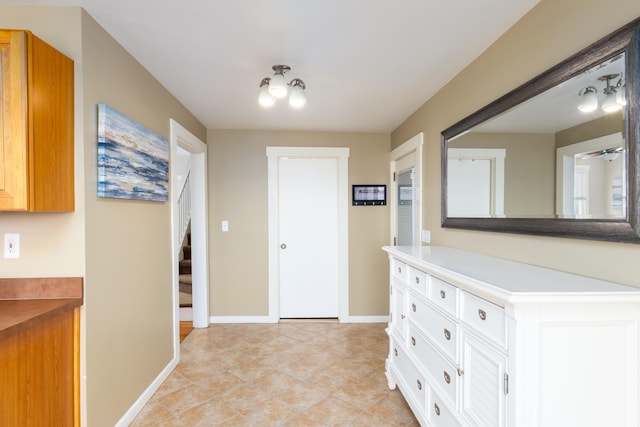 hallway with baseboards, stairway, and light tile patterned floors