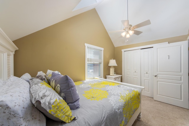 bedroom featuring a ceiling fan, a closet, lofted ceiling, and light colored carpet