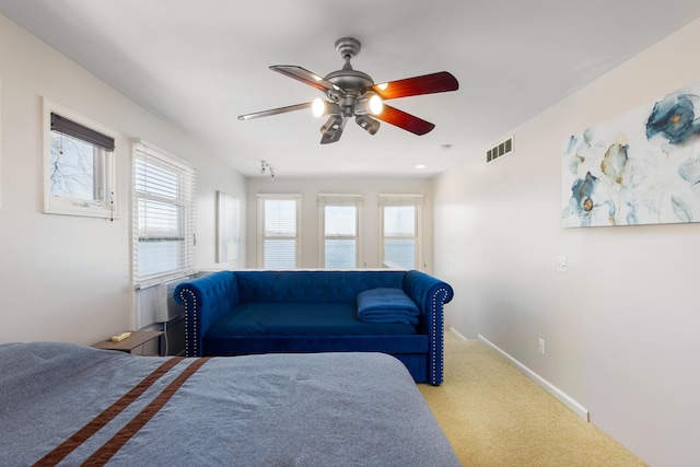 bedroom with baseboards, a ceiling fan, visible vents, and carpet