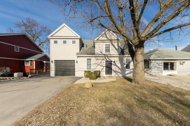 view of front of house featuring a garage, aphalt driveway, and central air condition unit