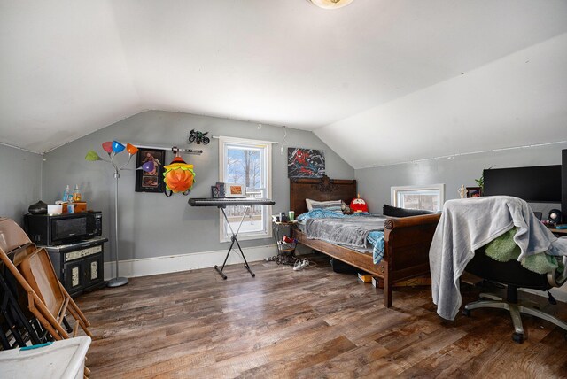 bedroom featuring hardwood / wood-style floors and vaulted ceiling