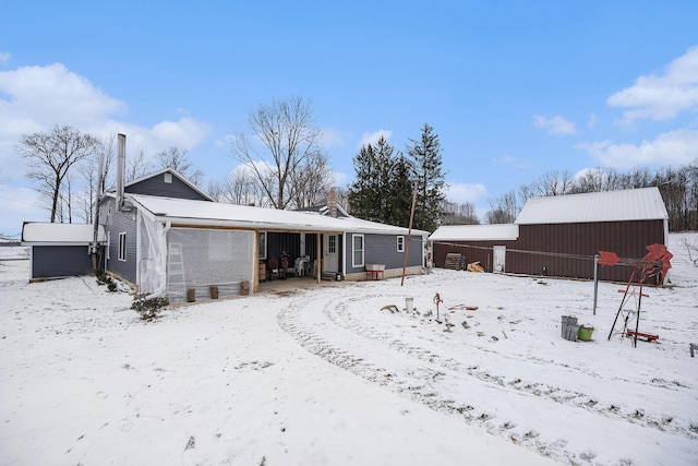 snow covered house featuring an outdoor structure