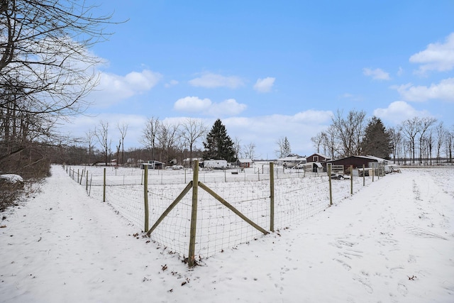 yard covered in snow with a rural view