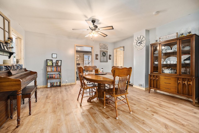 dining space featuring ceiling fan and light wood-type flooring