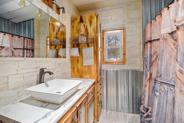 bathroom featuring wooden walls and vanity