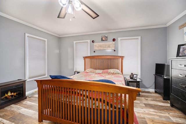 bedroom featuring ceiling fan, light wood-type flooring, and crown molding