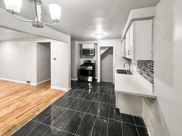 kitchen featuring white cabinetry, sink, and appliances with stainless steel finishes