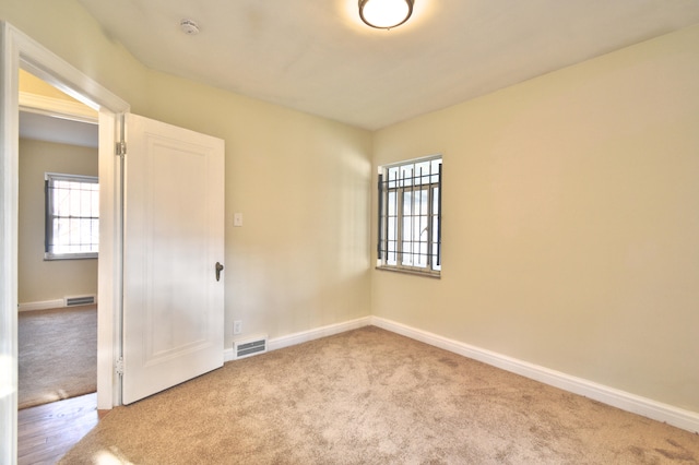 carpeted empty room with a healthy amount of sunlight