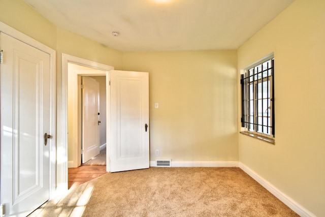 unfurnished bedroom featuring light carpet