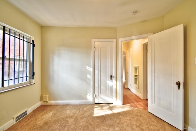 unfurnished bedroom with light colored carpet