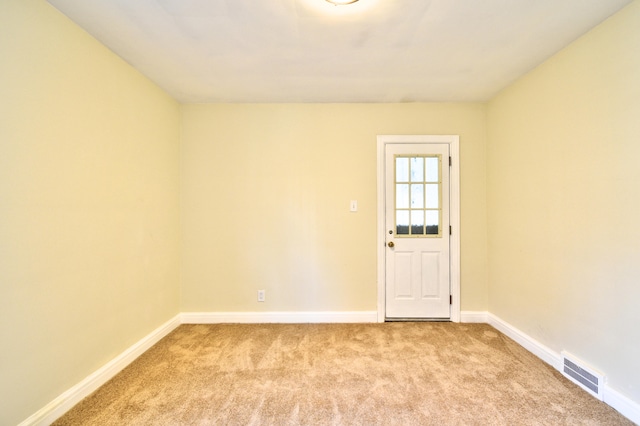 spare room featuring light carpet