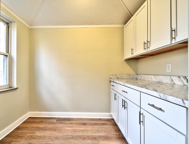 laundry room with light hardwood / wood-style flooring and ornamental molding