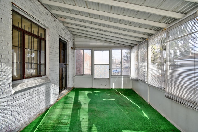 unfurnished sunroom featuring lofted ceiling with beams