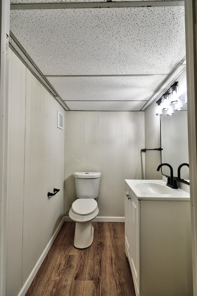 bathroom featuring wood-type flooring, vanity, and toilet