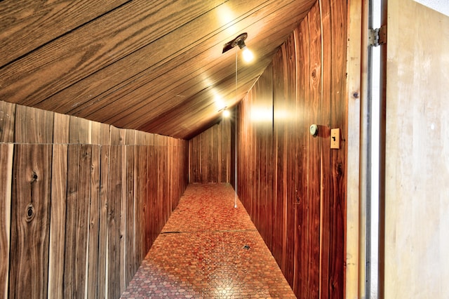 interior space featuring vaulted ceiling, wooden ceiling, and wood walls