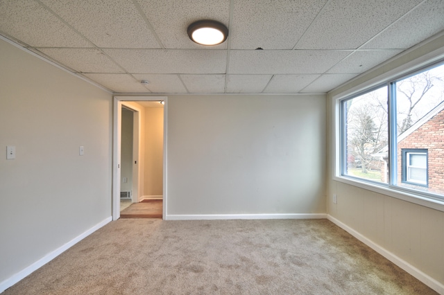 spare room with a drop ceiling and light carpet