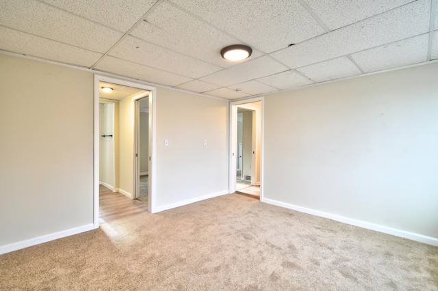 spare room with a paneled ceiling and carpet floors