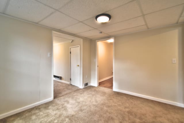 spare room with a paneled ceiling and carpet