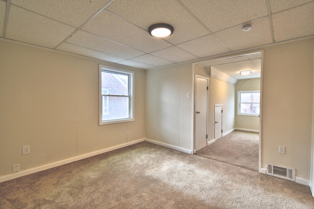 carpeted empty room featuring a paneled ceiling