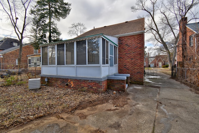 view of home's exterior with cooling unit and a sunroom