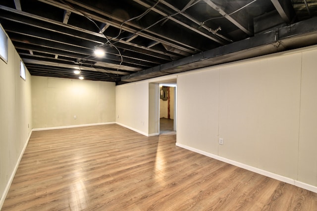 basement with light hardwood / wood-style flooring