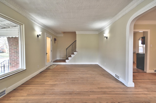 interior space with hardwood / wood-style floors, a textured ceiling, and ornamental molding