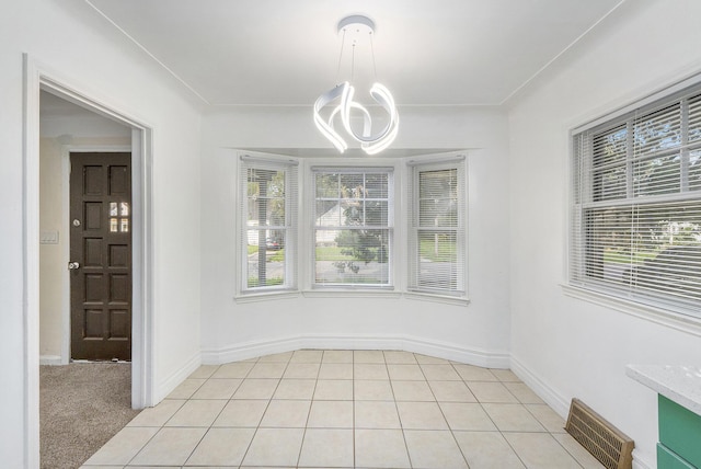 unfurnished dining area featuring plenty of natural light, light colored carpet, and an inviting chandelier