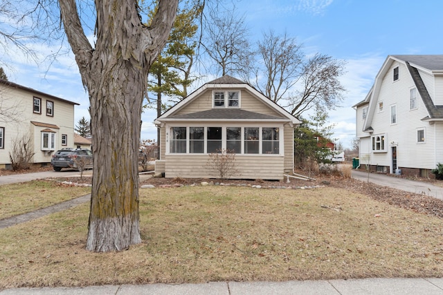 view of front of property featuring a front lawn and a sunroom