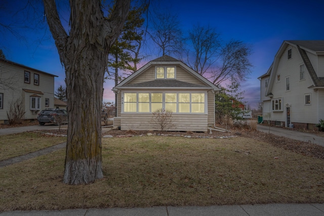 bungalow-style home with a lawn