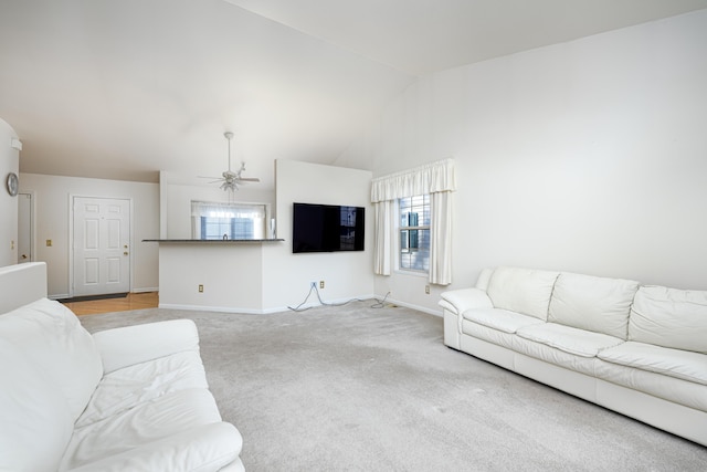 living room featuring ceiling fan, light carpet, and vaulted ceiling