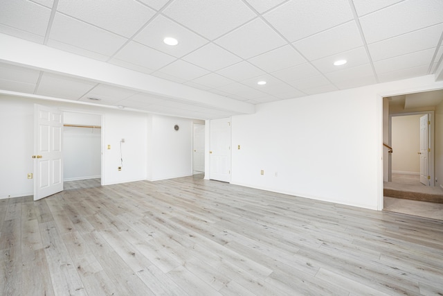 interior space featuring a drop ceiling and light wood-type flooring