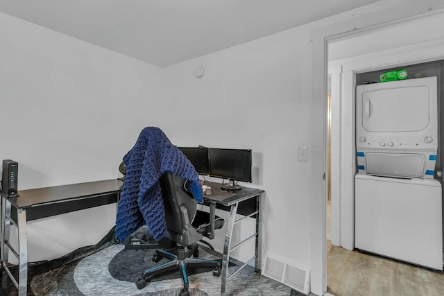 office space featuring wood-type flooring and stacked washer and clothes dryer