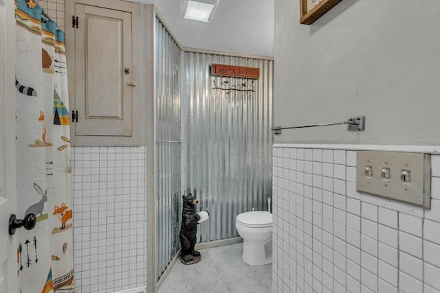 bathroom featuring a shower with curtain, toilet, and tile walls