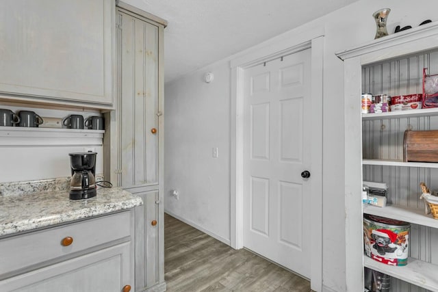 interior space with light stone counters and hardwood / wood-style flooring