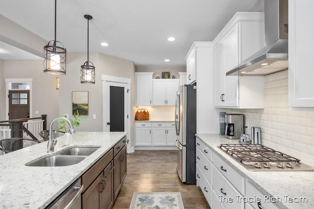 kitchen featuring white cabinetry, sink, and wall chimney range hood